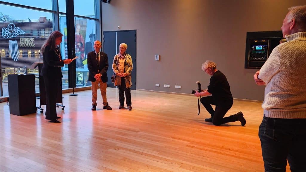 Piet Verhoeven wordt gefotografeerd samen met zijn vrouw en Burgemeester Anja Schouten.
