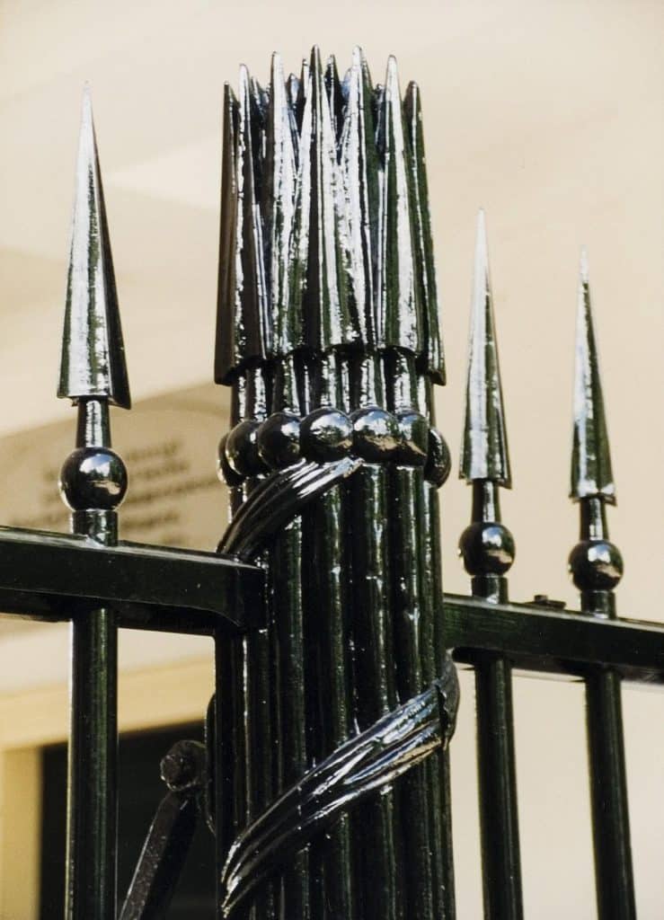 Detail van het hek van de Algemene Begraafplaats in de Westerhout. De gebonden pijlerbundel staat symbool voor de dood. Circa 2000