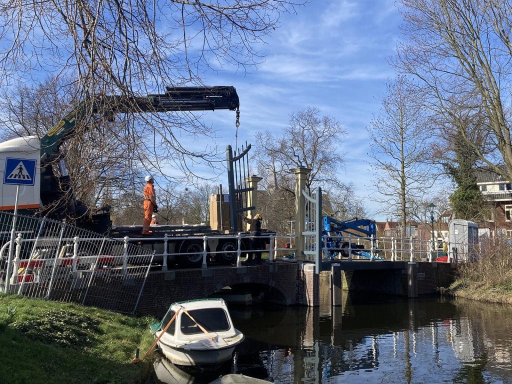 Plaatsing van het Nieuwlanderhek op de Popmansbrug over de Nieuwlandersingel.
