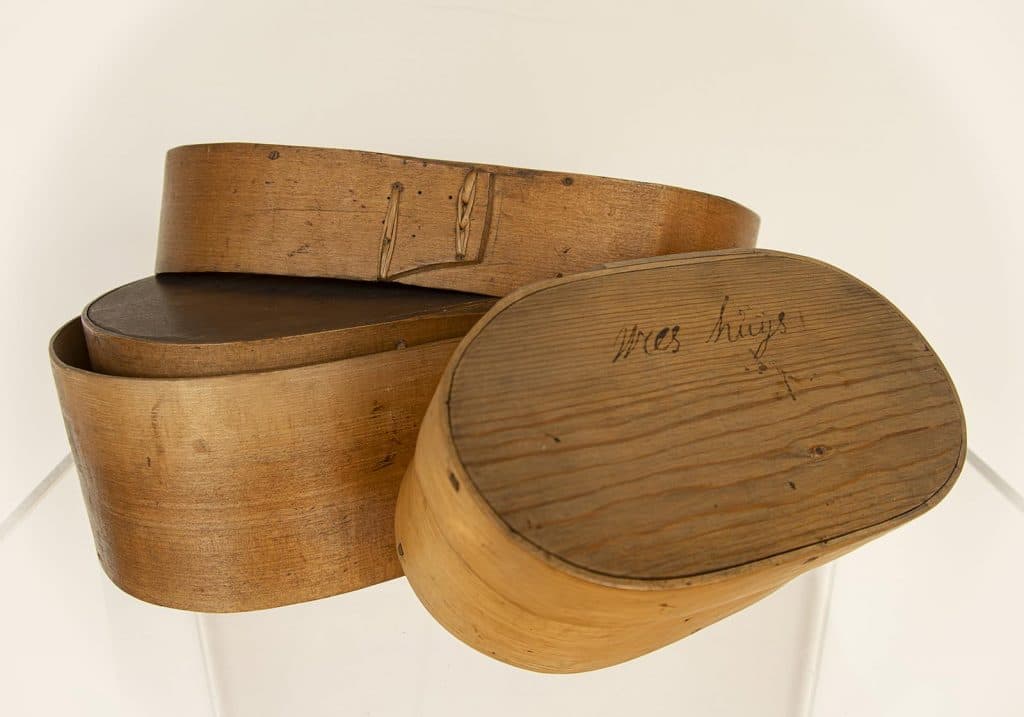 Ovale spanen doos van heel dun hout met massief houten deksel en onderkant. De spanen zijn omgebogen en vastgezet met riet. Op een van de deksels is het woord weeshuis gebrand. Op een andere Ánne Jans dingen 16?5.
