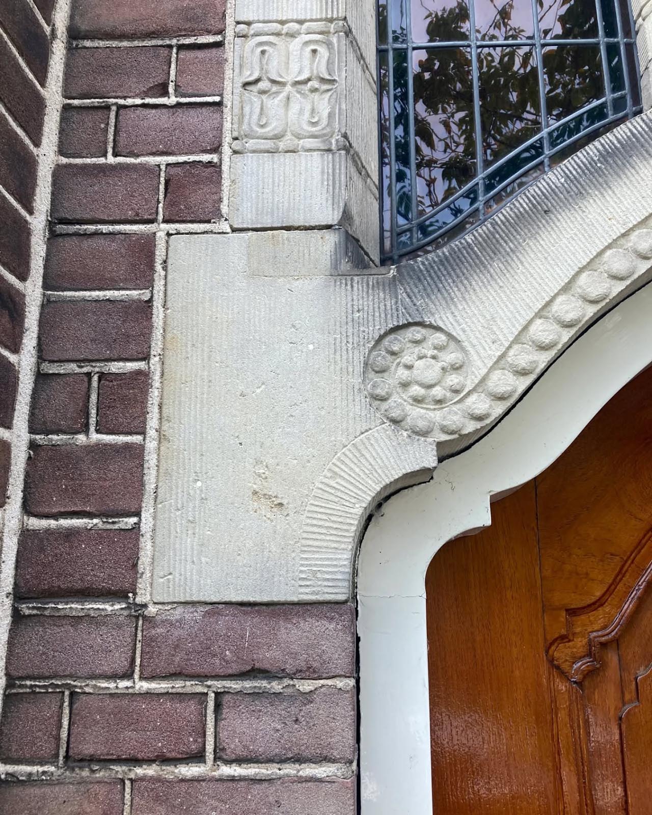 Fijn gedetailleerd natuursteen rond de voordeur aan de Nassaulaan.