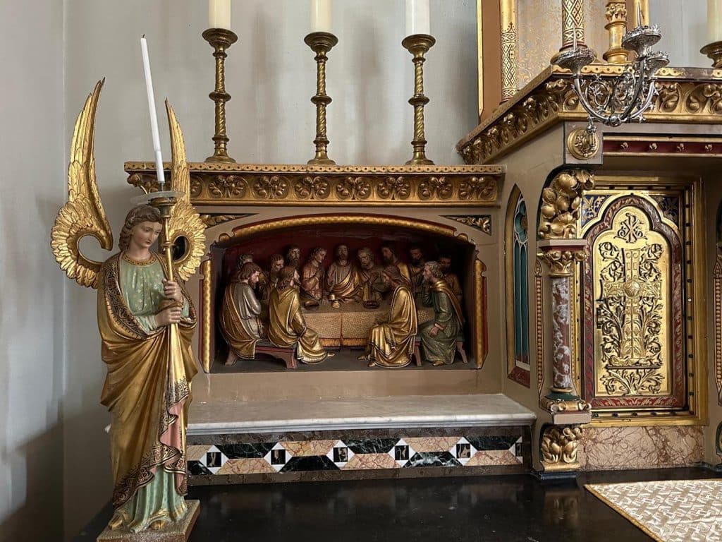 Detail van het altaar in de Sint Laurentiuskerk in Oudorp. Links een een engel en een hoogreliëf van het Laatste Avondmaal. Hieronder is de rand ingelegd met diverse soorten marmer.