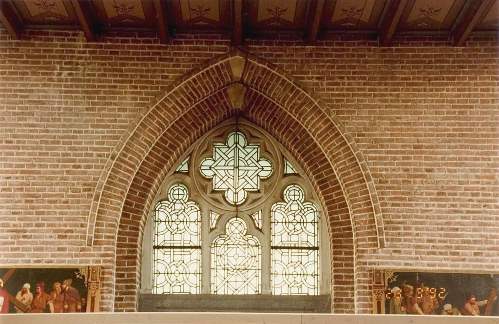 Glas-in-loodraam met spitsboog boven de entree in de Sint Laurentiuskerk in Oudorp. Hierboven bevind zich het orgel en het roosvenster. Foto J. Elsinga 1992.