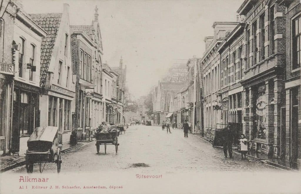 Prentbriefkaart van het straatbeeld in het Ritsevoort Langs de gevels liggen hardstenen stoepen Handkarren staan op straat Circa 1901