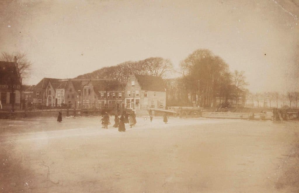 Schaatsenrijders op het Noordhollands Kanaal. Rechts de vlotbrug met daarachter het Victoriepark. Circa 1900.