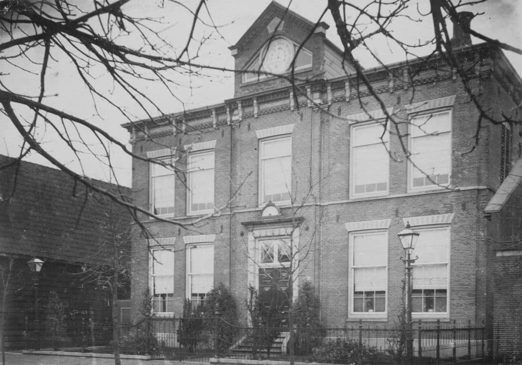 Het voormalig Doopsgezind Weeshuis aan de Tuingracht in De Rijp in 1894. Dit weeshuis staat vlakbij Museum In ‘t Houten Huis. In de geveltop is de barometer te zien. Vervaardigd door de firma van Emden in Amsterdam in 1865. De thermometer boven de voordeur werd in 1890 aangebracht. Deze werd vervaardigd door de firma H. Olland te Utrecht naar een patent van Cornelis Admiraal. De houten ombouw werd vervaardigd door P. van der Roest in De Rijp. Helemaal rechts is nog een stukje van het huis te zien waar de fotograaf Blaauw tot 1894 woonde. De houten zijwand van het huis aan de linkerzijde is in 1962 door een stenen muur vervangen.