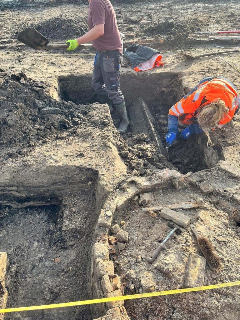Kayleigh en Kasper zijn bezig met het uitgraven van de donkere vulling van een langgerekte baan. Dit is aan de zuidkant van de waterput van een zeventiende-eeuwse stolp in Zuidschermer.