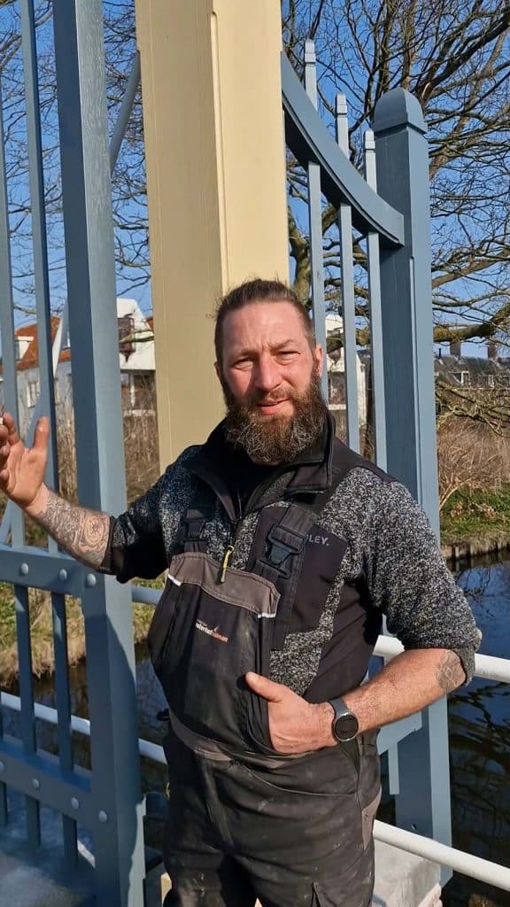 Chris Verloop bij het Nieuwlanderhek op de Popmansbrug. Het hek is gemaakt door Koninklijke Oosterhof Holman, in opdracht van Stadswerk072.
