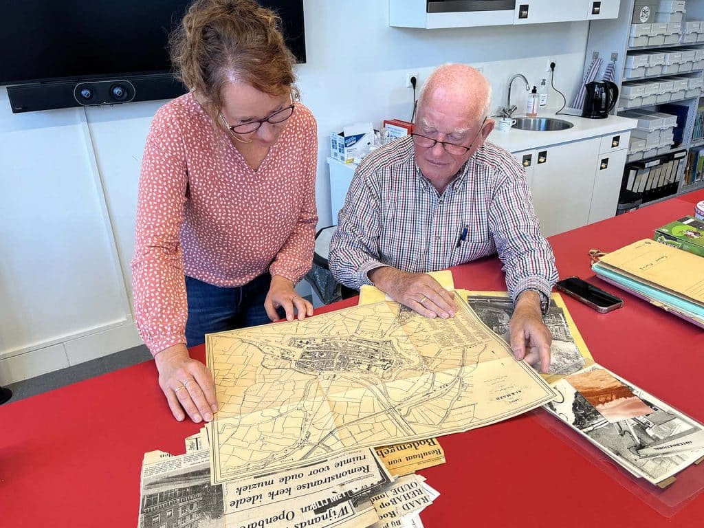 Frans van Marle buigt zich samen met Nancy de Jong over een plattegrond uit zijn verzameling.