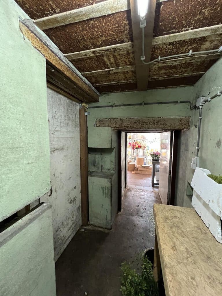 De dikke muren en de constructie van Bunker R617 is goed zichtbaar. Aan het einde van de gang zie je de bloemenwinkel. Foto M. Alphenaar 2016. Foto M. Alphenaar 2016.