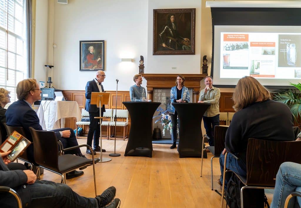 Mark Alphenaar van Regionaal Archief Alkmaar spreekt tijdens de presentatie. Auteurs Colette Cramer en Rutger Noorlander staan links naast hem. Foto Jan Jong.