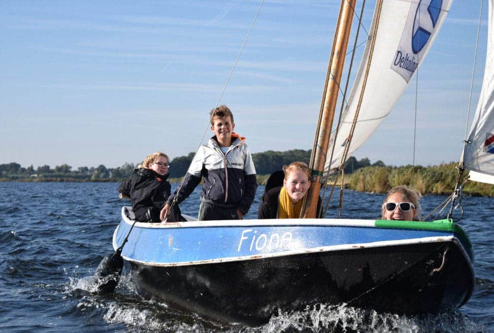Vier jongeren varen op een kleine zeilboot op het meer. De Vlet heet Fiona.