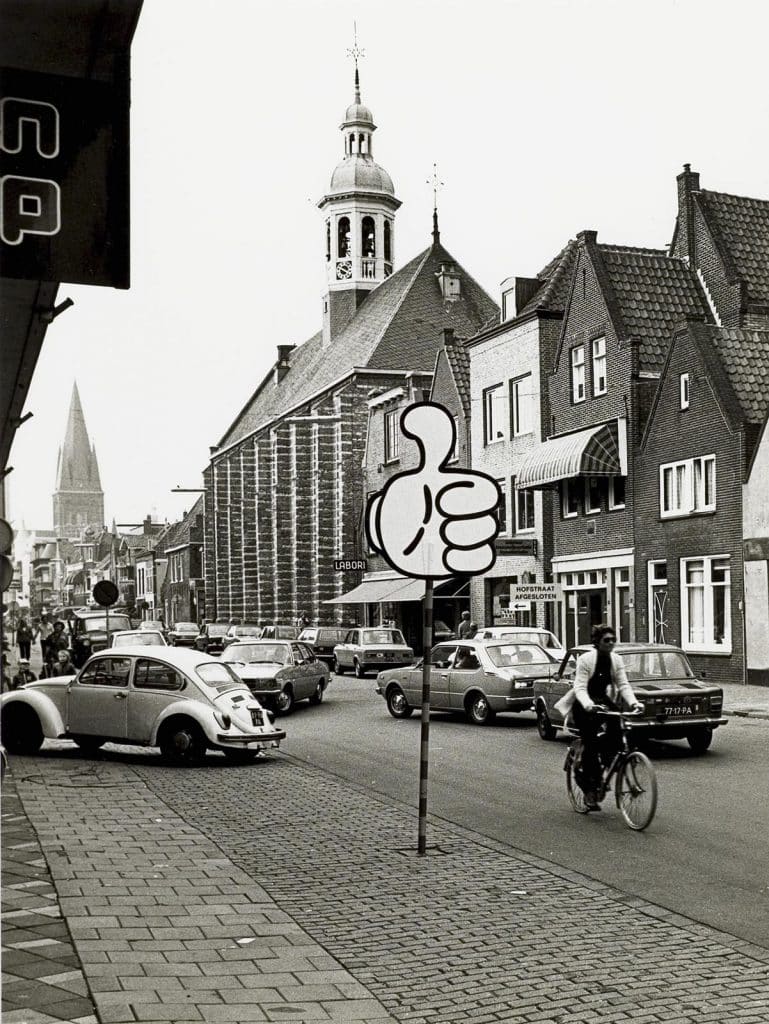 De Laat staat vol met geparkeerde auto's. Links zie je de toren van de Dominicuskerk.
