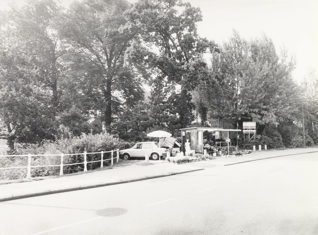 Het Grote- of Kennemerbolwerk, in het park op de stadswallen. Tussen de bomen de Molen van Piet, ook wel genoemd Molen de Groot. Naast het bloemenstalletje begint het pad. Rechts daarvan staat de telefoonbunker. Op de voorgrond ligt de Heilooërbrug en begint het Ritsevoort.