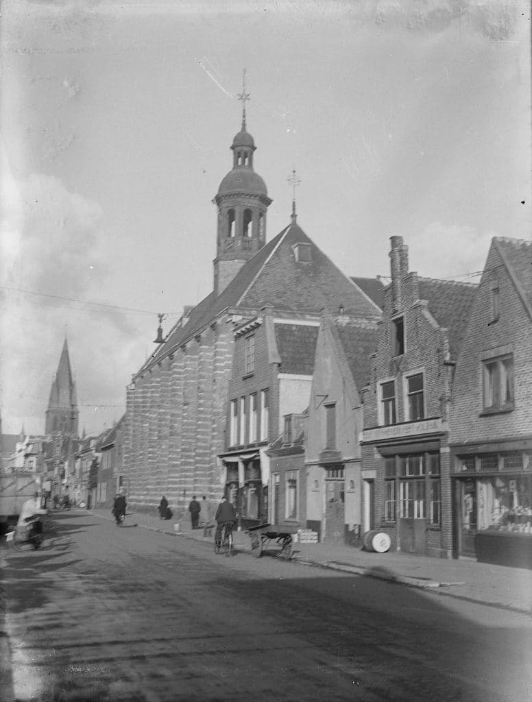 Gevels noordkant waaronder links Dominicuskerk, midden Kapelkerk. Rechts Ploeg den Hartigh aardappelhandel, nr 60 T. Wolzak smederij, nr 58 Gezusters Deen gelukshuis. Fietsers op de Laat en 1 handkar.