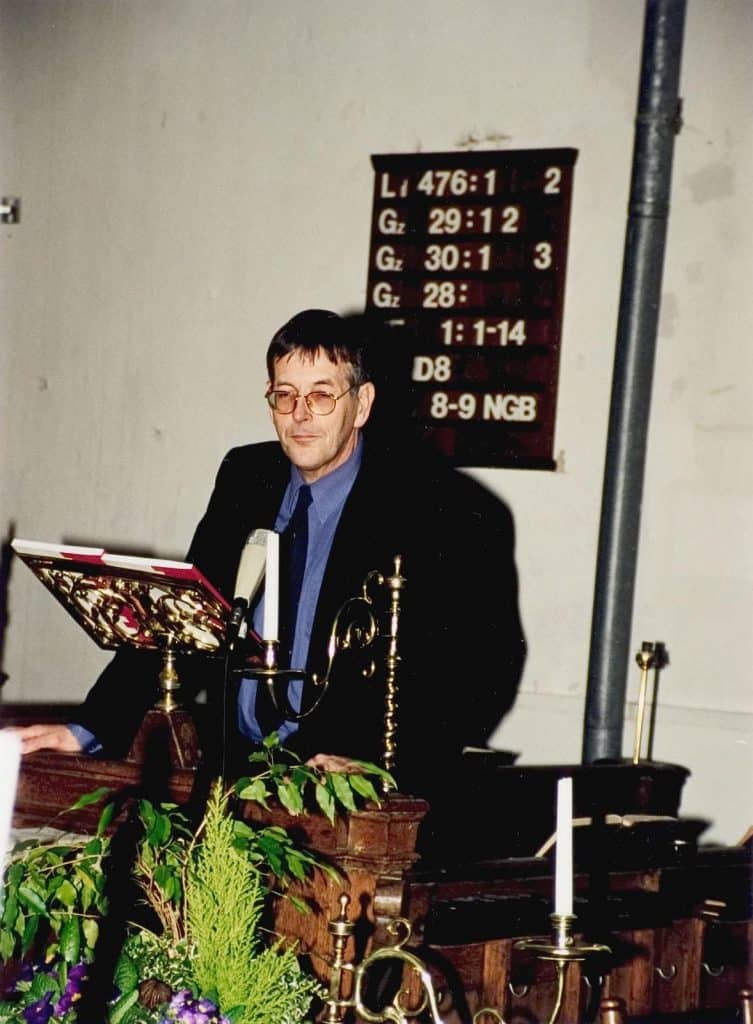 Interieur kerkzaal, tijdens de heropening. Piet Verhoeven houdt een toespraak.