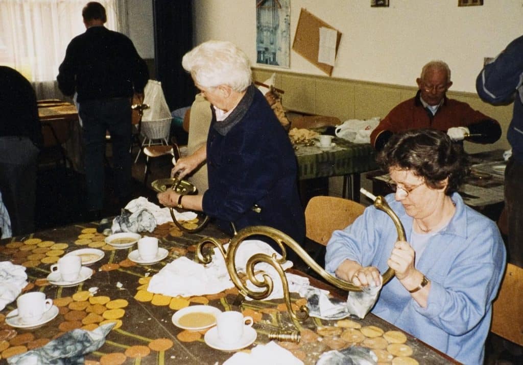 In de consistorie worden de armaturen van de kroonluchters gepoetst door vrijwilligers.