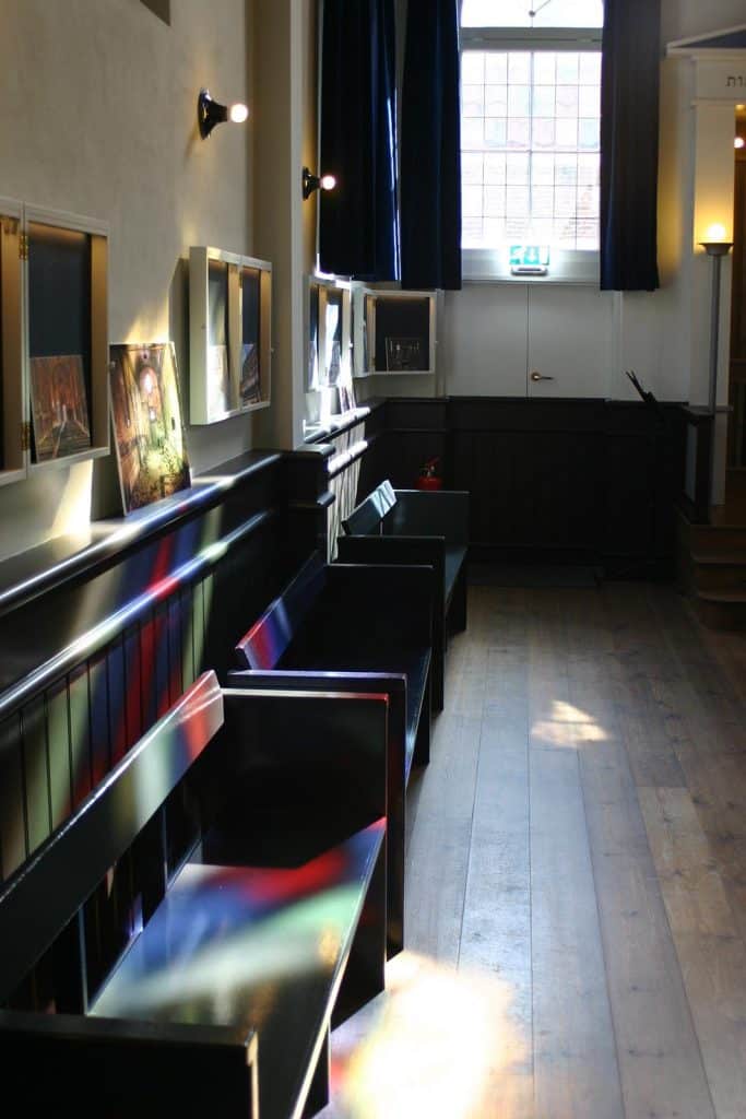 Interieur van de Alkmaarse Synagoge in 2017. Met gekleurd licht dat naarbinnen valt door het glas-in-loodraam.