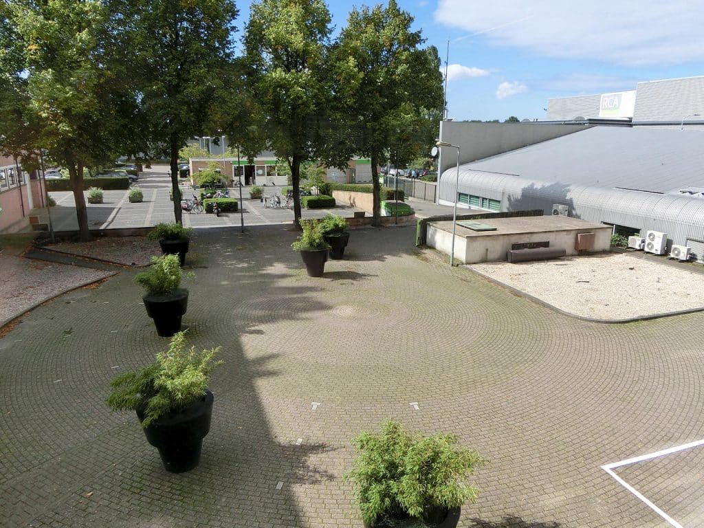 Rechts op het plein is een klein gebouwtje te zien die bedoeld is voor de luchtzuivering van de atoombunker onder het plein.