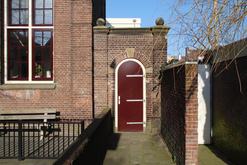 Poort op het schoolplein naast het hoofdgebouw van Basisschool Bello in 2014