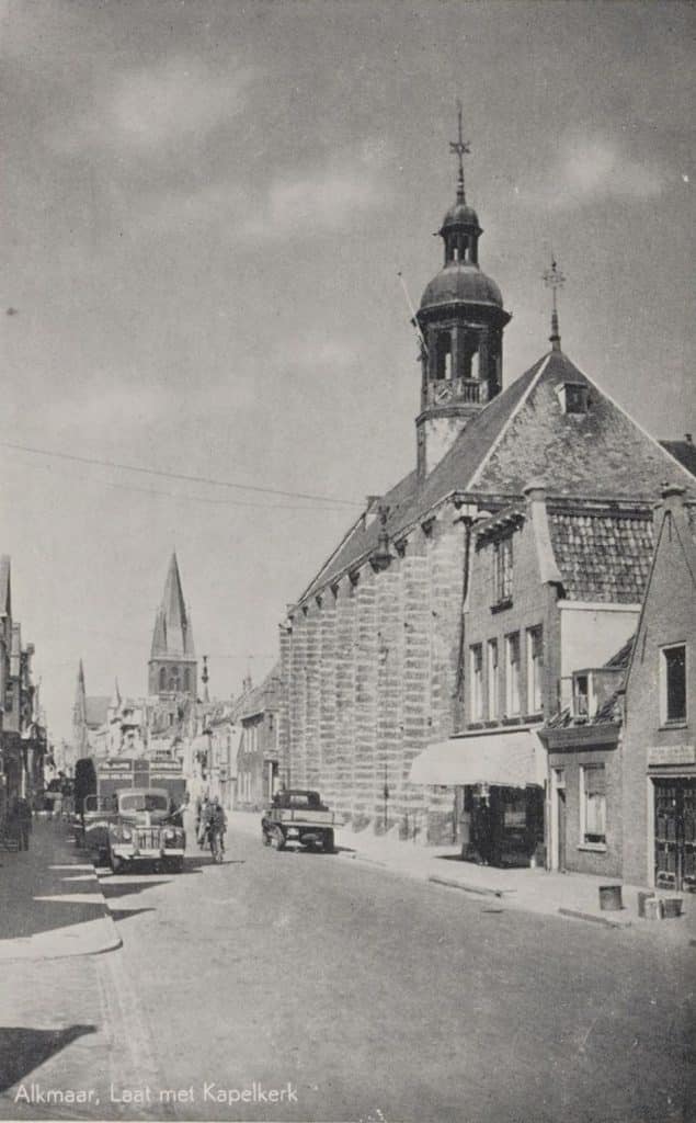 Van recht naar links gedeeltelijk Laat 74, Laat 76, Laat 78 en de Kapelkerk. Langs de gevels liggen trottoirs. Op straat rijden er auto's en fietsers.