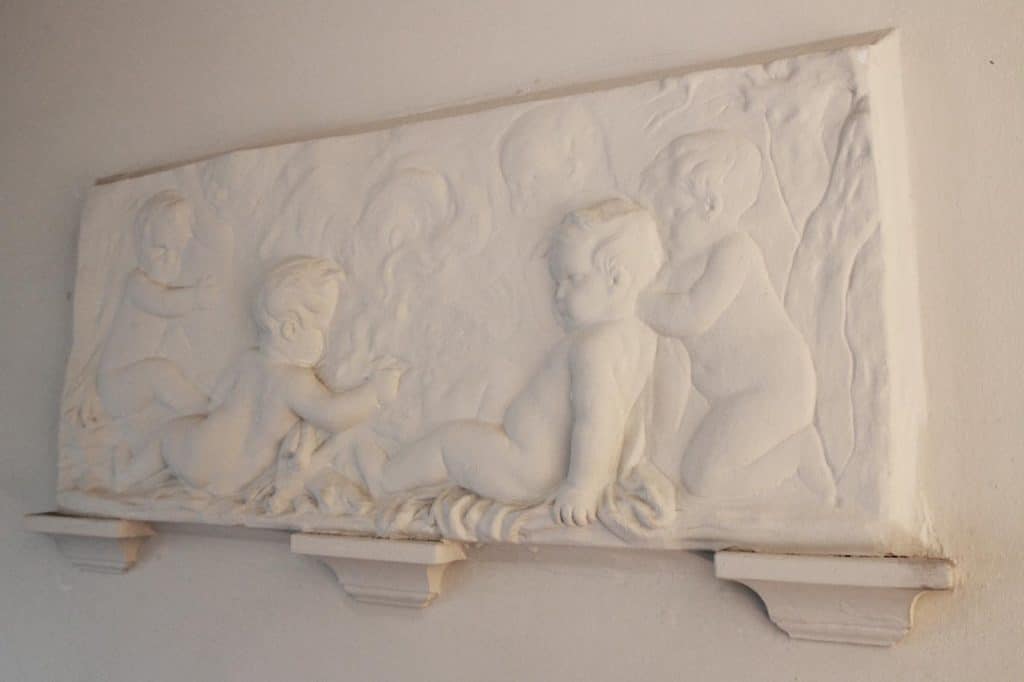 Sculptuur op de muur van het trappenhuis van Basisschool Bello