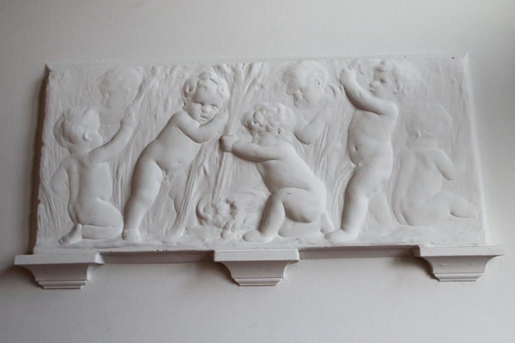 Sculptuur op de muur van het trappenhuis van Basisschool Bello