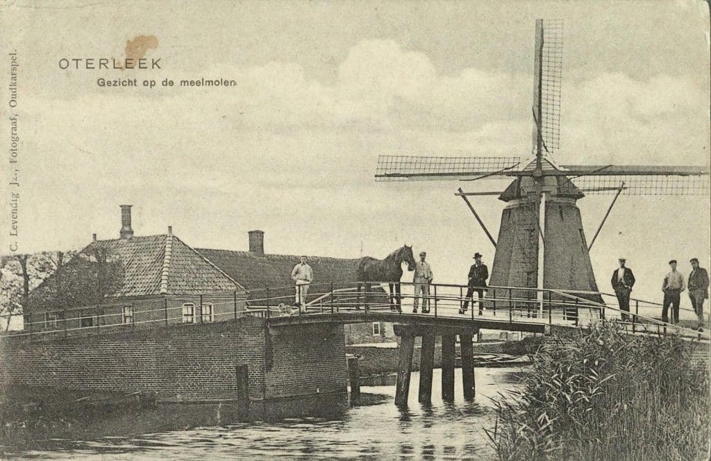 Op de brug zes mannen. De tweede man houdt een paard vast.