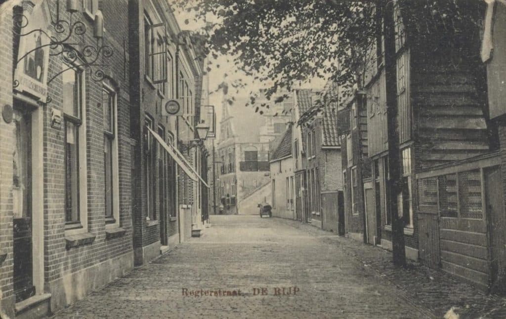 Weg is nu alles wat ver de straat in steekt, zoals zonneschermen en uithangtekens. Verdwenen zijn ook veel lommerrijke bomen, het gaslicht, de telefoonpalen en de bakkerskar. Daarvoor in de plaats hebben we nu gerestaureerde huizen, elektrisch licht en een rij geparkeerde auto’s. Het eerste huis links heet De Friesche Boer (nu 122), het hoge houten huis rechts heet inmiddels De Dondersteen (nu 71).